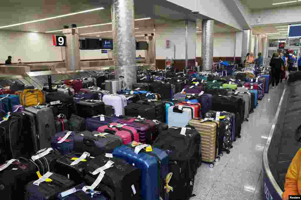 People wait to retrieve their luggage after long delays following cyber outages affecting airlines at Hartsfield-Jackson Atlanta International Airport in Atlanta, Georgia, U.S..