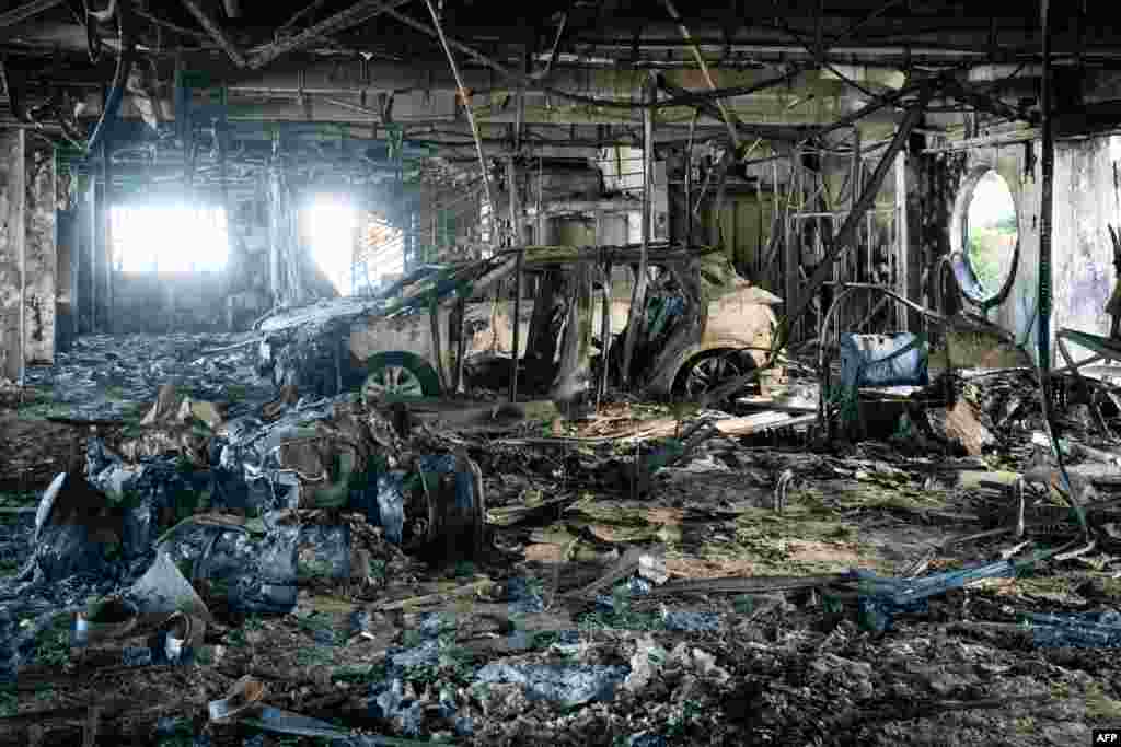 A fire-damaged vehicle is seen inside the Sodauto car dealership in Magenta, suburbs Vallee des Colons, in France's Pacific territory of New Caledonia in Noumea, more than two weeks after deadly riots broke out in the Pacific territory.