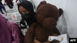 A Nigerian student fleeing Sudan clutches a stuffed bear while at the Nnamdi Azikwe International Airport in Abuja, Nigeria, May 4, 2023.