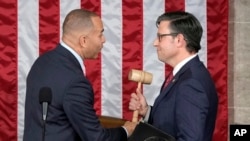 U.S. House Minority Leader Hakeem Jeffries, D-N.Y., hands the gavel to Speaker-elect Mike Johnson, R-La., at the Capitol in Washington, Oct. 25, 2023.