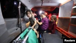 Timoun chita nan yon anbilans nan lopital Shifa a apre yon atak ak misil frape lopital Al-Ahli nan Gaza Siti, 17 Oktob, 2023.