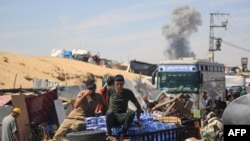 Smoke billows following Israeli bombardment as displaced Palestinians move, in Rafah in the southern Gaza Strip, on May 31, 2024.