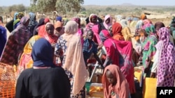 Refugees fleeing the conflict in Sudan queue with their jerrycans to collect drinking water at a distribution point at the Ourang refugee camp in Adre, Chad, Dec. 7, 2023.