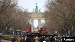 Спалений у селі Дмитрівка під Києвом російський танк T-72 виставлений біля Бранденбурзьких воріт у Берліні в Німеччині в річницю вторгнення Росії в Україну. 24 лютого 2023 р.