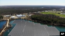 An array of solar panels float on top of a water storage pond in Sayreville, N.J., Monday, April 10, 2023. (AP Photo/Seth Wenig)
