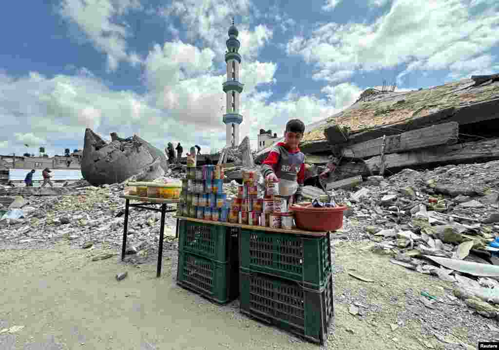 A boy stands next to canned food on the day of Friday prayers during the holy fasting month of Ramadan, amid the ongoing conflict between Israel and the Palestinian Islamist group Hamas, in Rafah, in the southern Gaza Strip.