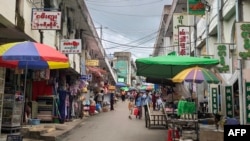 FILE - People walk through a market in Lashio in Myanmar's northern Shan State on June 18, 2024.