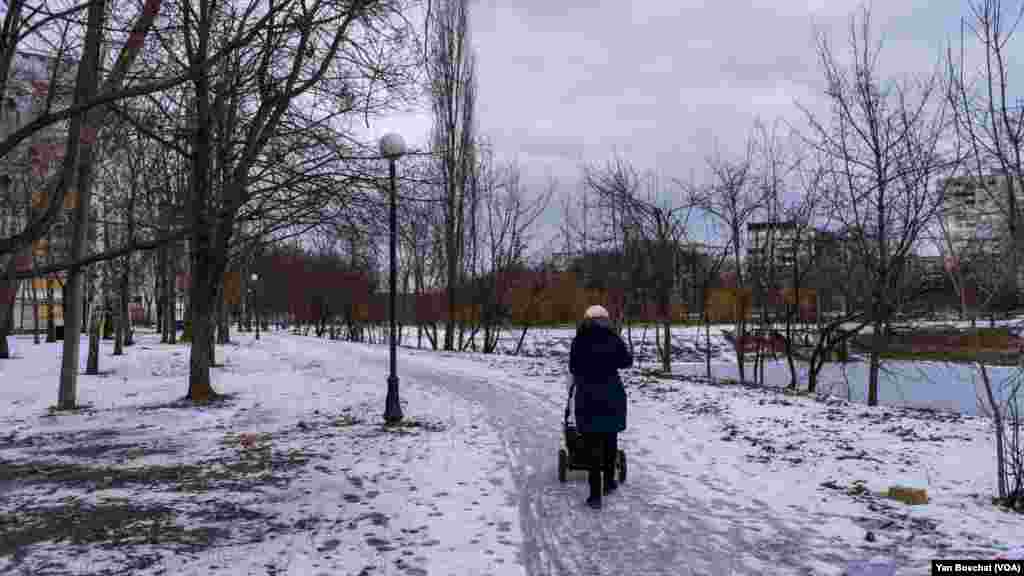 On a quiet Feb. 15, 2023, a young mother strolls with her baby in Saltivka, near what a few months ago was the front line between Ukrainian and Russian forces in Kharkiv.
