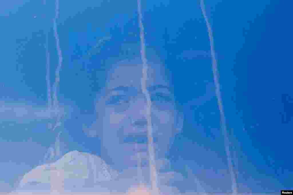 A Palestinian girl cries while sitting inside a vehicle, before she is transferred for treatment abroad without being accompanied by her parents, through the Kerem Shalom crossing, in Khan Younis in the southern Gaza Strip.