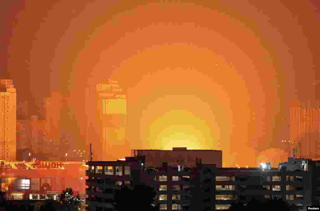 A flash from the explosion of a missile illuminates the city during a Russian missile strike in Kyiv, Ukraine.