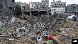 Beberapa warga Palestina memeriksa kehancuran setelah serangan udara Israel di sebuah bangunan permukiman di kota Deir al Balah, Jalur Gaza, 14 Januari 2024.