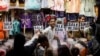 People buy dresses from a shop in a market ahead of Eid al-Fitr celebrations in Karachi, Pakistan, April 19, 2023.