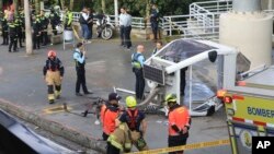 Policías y bomberos junto a un teleférico tirado en el suelo después de caer en Medellín, Colombia, el
26 de junio de 2024.