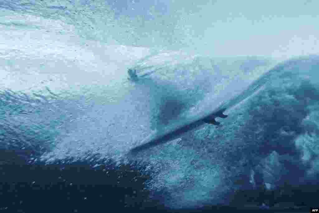 A surfer takes part in a training session in Teahupo'o, on the French Polynesian Island of Tahiti, July 22, 2024, ahead of the Paris 2024 Olympic Games.