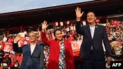Thai candidates for prime minister Paetongtarn Shinawatra (C), Srettha Thavisin (R) and Chaikasem Nitisiri (L) wave during a rally for Thailand's main opposition Pheu Thai party at the Thunder Dome Stadium north of Bangkok, April 5, 2023.