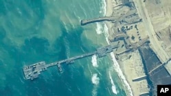 La imagen proporcionada por el Comando Central de EE. UU. muestra a soldados del Ejército de EE. UU., marineros de la Marina de EE. UU. y Fuerzas de Defensa de Israel colocando el muelle Trident en la costa de la Franja de Gaza el 16 de mayo de 2024.