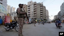 FILE - Tentara paramiliter berjaga di sepanjang pinggir jalan untuk memastikan keamanan di Karachi, Pakistan, Selasa, 9 April 2024. (AP/Fareed Khan)
