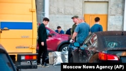 Tim investigasi tampak memeriksa lokasi jatuhnya drone asal Ukraina di Krasnogorsk, di luar Kota Moscow, Rusia, pada 22 Agustus 2023. (Foto: Moscow News Agency via AP)