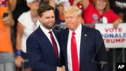 Republican vice presidential candidate Sen. JD Vance, R-Ohio, left, and Republican presidential candidate former President Donald Trump shake hands at a campaign rally at Georgia State University in Atlanta, Aug. 3, 2024.
