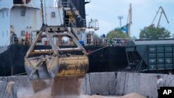 FILE - Workers load grain at a grain port in Izmail, Ukraine, April 26, 2023.