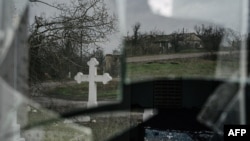 ARCHIVO - Una cruz se refleja en una ventana rota de la iglesia de un pueblo en la región de Jersón, en el sur de Ucrania, en medio de la invasión rusa, el 30 de diciembre de 2022.