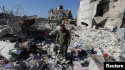 FILE - Naser al-Wakaa stands on the rubble of his home, ruined in the Feb. 6 earthquakes, in the rebel-held town of Jandaris, Syria, Feb. 9, 2023.