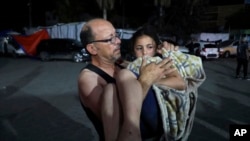 A Palestinian moves a child wounded in an Israeli bombardment on the Gaza Strip to Al Aqsa hospital in Deir al Balah, central Gaza Strip, May 30, 2024. 