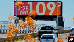 FILE - A digital billboard displays an unofficial temperature on July 17, 2023, in downtown Phoenix. 