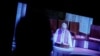 Un periodista observa una transmisión televisiva en vivo mientras el sacerdote Josu López Villalba, víctima de abuso sexual, habla durante una misa en Bilbao, España, 24 de marzo de 2023. 