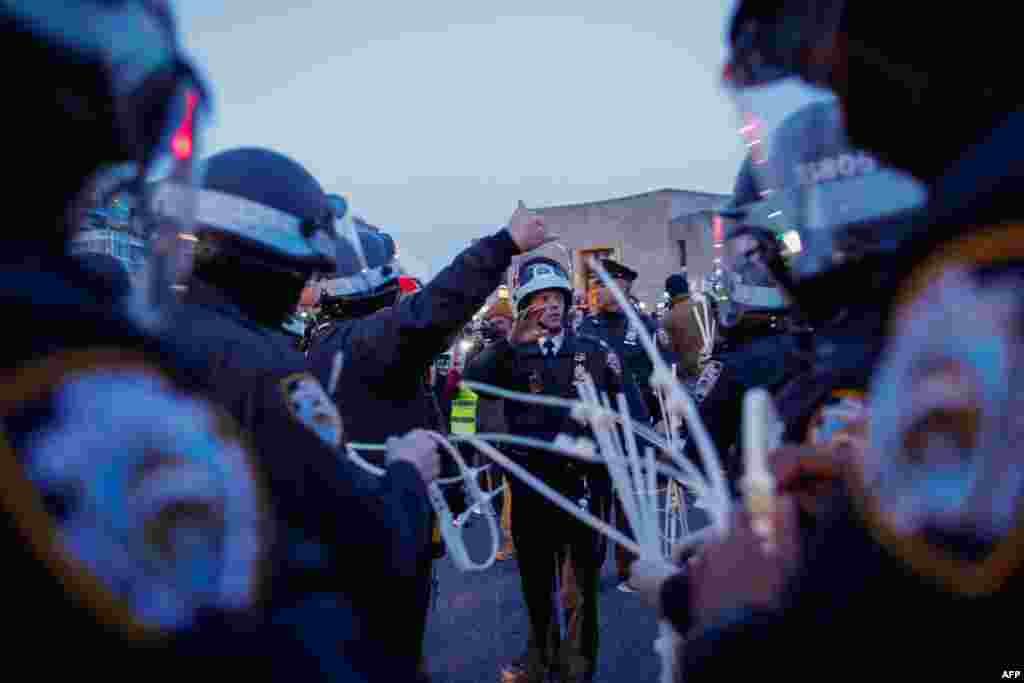 Police officers hold plastic handcuffs as they prepare to detain protesters blocking a street near the home of U.S. Senate Majority Leader Chuck Schumer in the Brooklyn borough of New York during a demonstration calling on Schumer to stop arming Israel amid its retaliatory assault on the Gaza Strip.