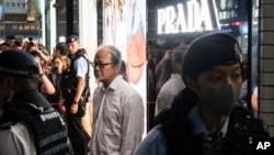 Petugas kepolisian menahan seniman Sanmu Chen di area Causeway Bay di Hong Kong jelang peringatan kekerasan tragedi Tiananmen Square ke-35 pada 3 Juni 2024. (Foto: AP/Chan Long Hei)