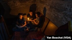 From left: Mark (11), Vlad (11) and Yelisej (9) live with their parents and a cat in this little basement in New York, Ukraine, on Feb. 20, 2023.