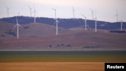 A fence is seen in front of wind turbines that are part of the Infigen Energy Capital Wind Farm located on the hills surrounding Lake George, near the Australian capital city of Canberra, Australia Feb. 21, 2018. 