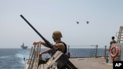 Two U.S. Air Force fighter jets fly alongside USS Bataan and USS Thomas Hudner in the Gulf of Oman.