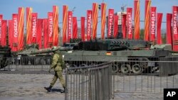 ARCHIVO - Un soldado ruso pasa junto a un tanque Leopard 2A6 decomisado en Ucrania. 