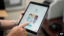 An employee of Hazel Health displays the opening page of the company's app, Tuesday, Oct. 10, 2023 (AP Photo/Rebecca Blackwell)