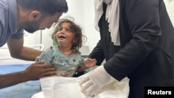 A Palestinian child, wounded in an Israeli strike on an area designated for displaced people, is assisted at a hospital, amid the ongoing conflict between Israel and Hamas, in Rafah in the southern Gaza Strip, May 26, 2024. 