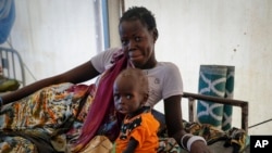 FILE - A mother sits with her malnourished baby at a hospital run by Medicines Sans Frontieres (Doctors Without Borders) in Old Fangak in Jonglei state, South Sudan, Dec. 28, 2021. Thousands of people in the country still depend on aid from the outside.