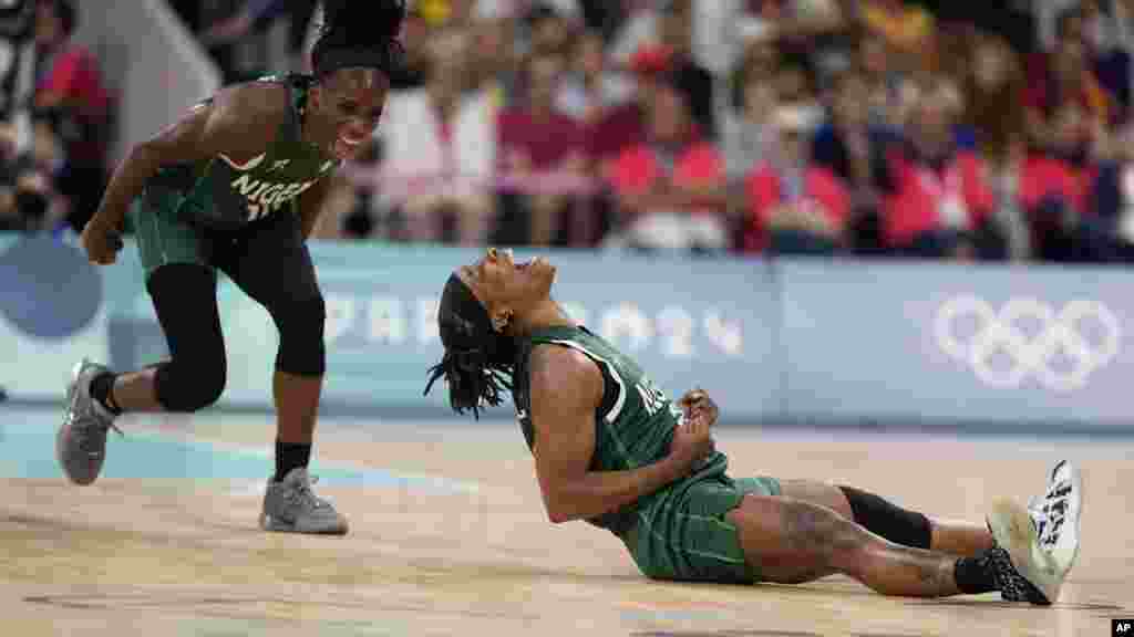 Ezinne Kalu (23), and Promise Amukamara (10) of Nigeria celebrate in a women's basketball game against Canada at the 2024 Summer Olympics in Villeneuve-d'Ascq, France.