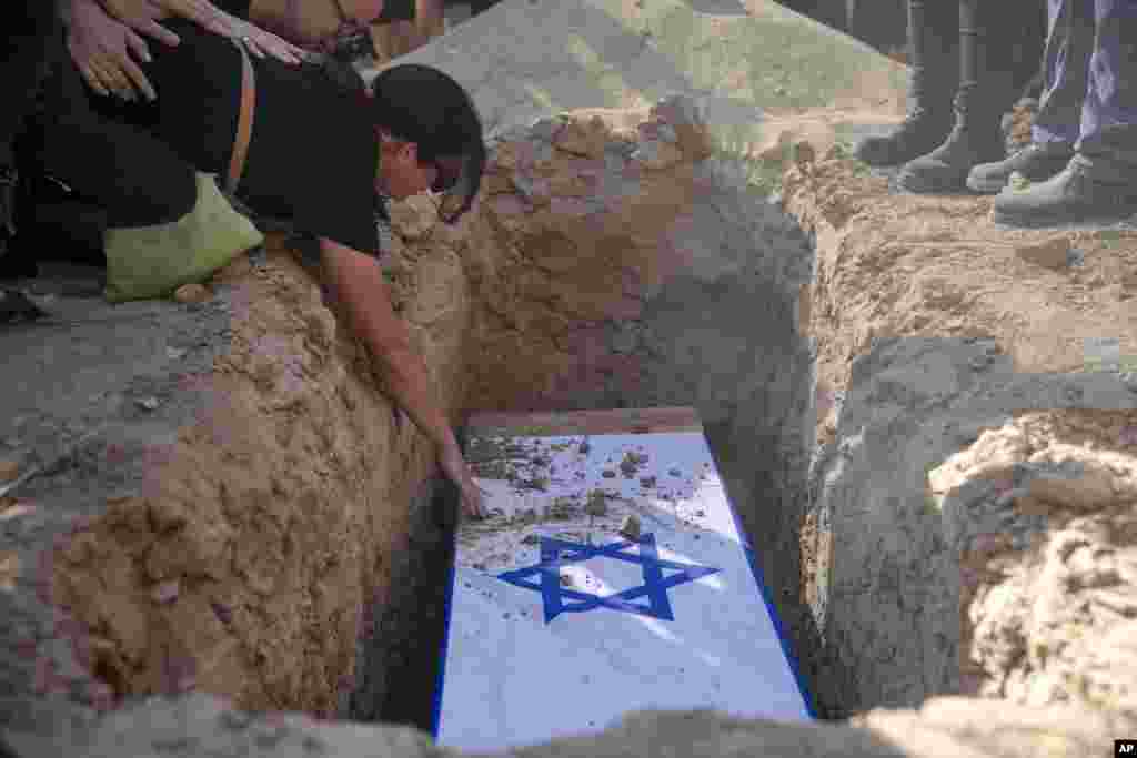 Rimon Buchshtab mourns during the funeral of her husband Yagev Buchshtab at a cemetery of the Kibbutz Nirim, southern Israel. Buchshtab's body was one of six bodies of hostages, taken in Hamas' Oct. 7 attack, recovered by Israel's military during an operation in the Gaza Strip.