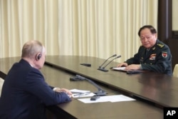 Russian President Vladimir Putin, left, speaks to Gen. Zhang Youxia, vice chairman of China's Central Military Commission, during a meeting at the Novo-Ogaryovo residence outside Moscow, Russia, Nov. 8, 2023.