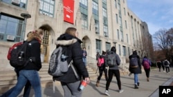 FILE - Students walk past an entrance to Boston University College of Arts and Sciences in Boston, Nov. 29, 2018. A new report says student visa denial rates are higher for students from Africa than any other region. 