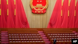 Seorang pejabat bersiap jelang rapat pleno kedua Kongres Rakyat Nasional (NPC) di Aula Besar Rakyat di Beijing, China, Jumat, 8 Maret 2024. (Foto: Tatan Syuflana/AFP).