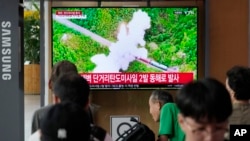 19일 한국 서울역 이용객들이 북한 단거리 탄도미사일(SRBM) 2발 발사 TV뉴스를 시청하고 있다.