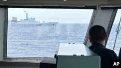 中国海警船在菲律宾近海的第二托马斯海滩（仁爱礁）海域阻拦菲律宾海岸警卫队巡逻船。（资料照， 2023年10月4日）