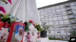 A candle with the image of Pope Francis is left in front of the windows of the Agostino Gemelli University Polyclinic in Rome, June 11, 2023, where Pope Francis is recovering from the abdominal surgery he underwent on Wednesday. 