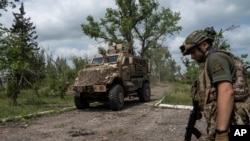 A Ukrainian serviceman of 68th Oleksa Dovbush hunting brigade patrols a street in the recently retaken village of Blahodatne, Ukraine, June 17, 2023.