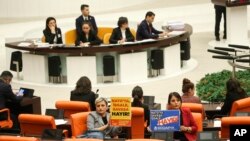 Anggota parlemen Turki dari partai Kebebasan Sosial (latar depan kiri), dan Platform Solidaritas Sosialis memegang poster bertuliskan dalam bahasa Turki: "Tidak ada pendudukan, tidak ada perang untuk NATO!" di Parlemen Turki di Ankara, 23 Januari 2024. (AP/Ali Unal)