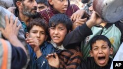 Palestinians line up for food in Rafah, Gaza Strip, Nov. 30, 2023, during a temporary ceasefire between Israel and Hamas.