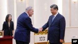 Visiting US Senate Majority Leader Chuck Schumer is greeted by Chinese President Xi Jinping before their bilateral meeting at the Great Hall of the People in Beijing, Oct. 9, 2023.